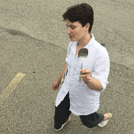claire in a parking lot holding a large serving spoon